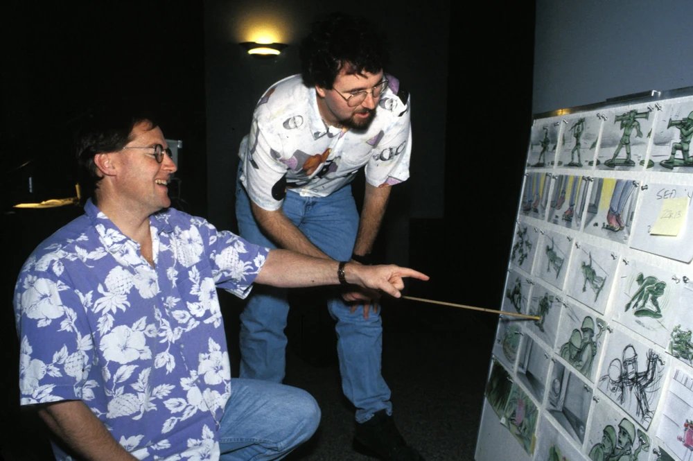Lasseter and Ranft laughing at a storyboard wall
