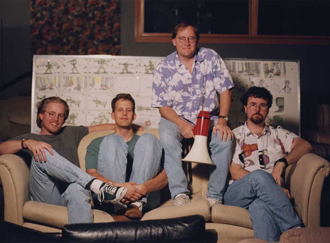 The four filmmakers seated together in front of Toy Story storyboards